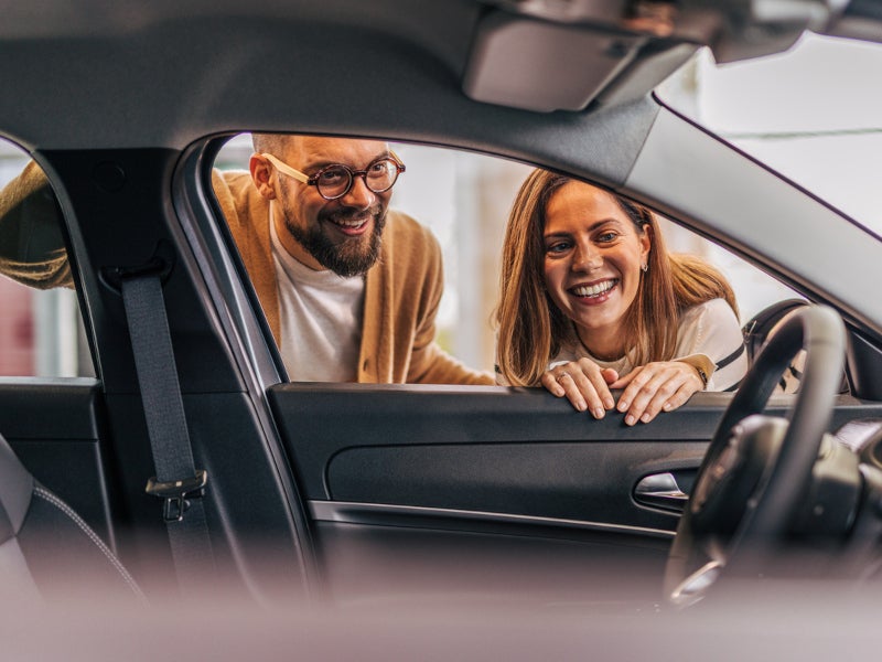Customers examing the interior of a cadillac